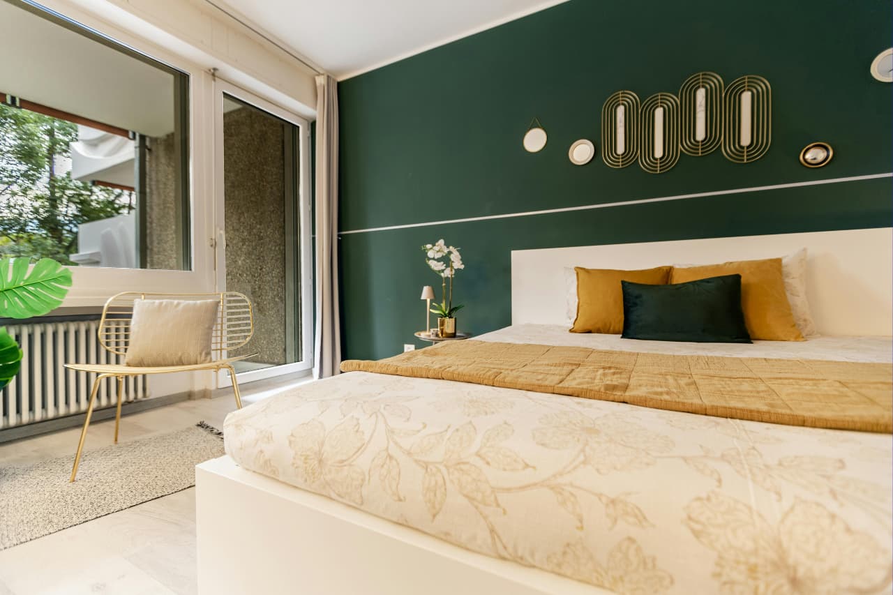 Chambre avec mur peint en vert forêt et décoration dorée